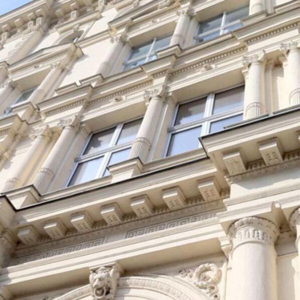 A classical building facade with ornate columns, large windows, and decorative moldings.