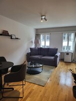 Una sala de estar con un sofá, una mesa de centro, una lámpara y un radiador.