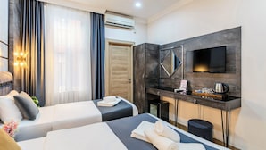 A hotel room with two beds, a desk, a flat-screen TV, and an air conditioning unit. - La Pazza Suites (Istanbul)