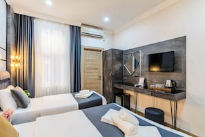 A hotel room with two beds, a desk, a flat-screen TV, and an air conditioning unit. - La Pazza Suites (Istanbul)