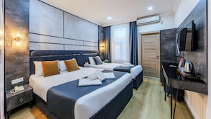 A modern hotel room with two beds, a desk, a TV, and an air conditioning unit. - La Pazza Suites (Istanbul)