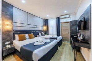 A modern hotel room with two beds, a desk, a TV, and an air conditioning unit. - La Pazza Suites (Istanbul)
