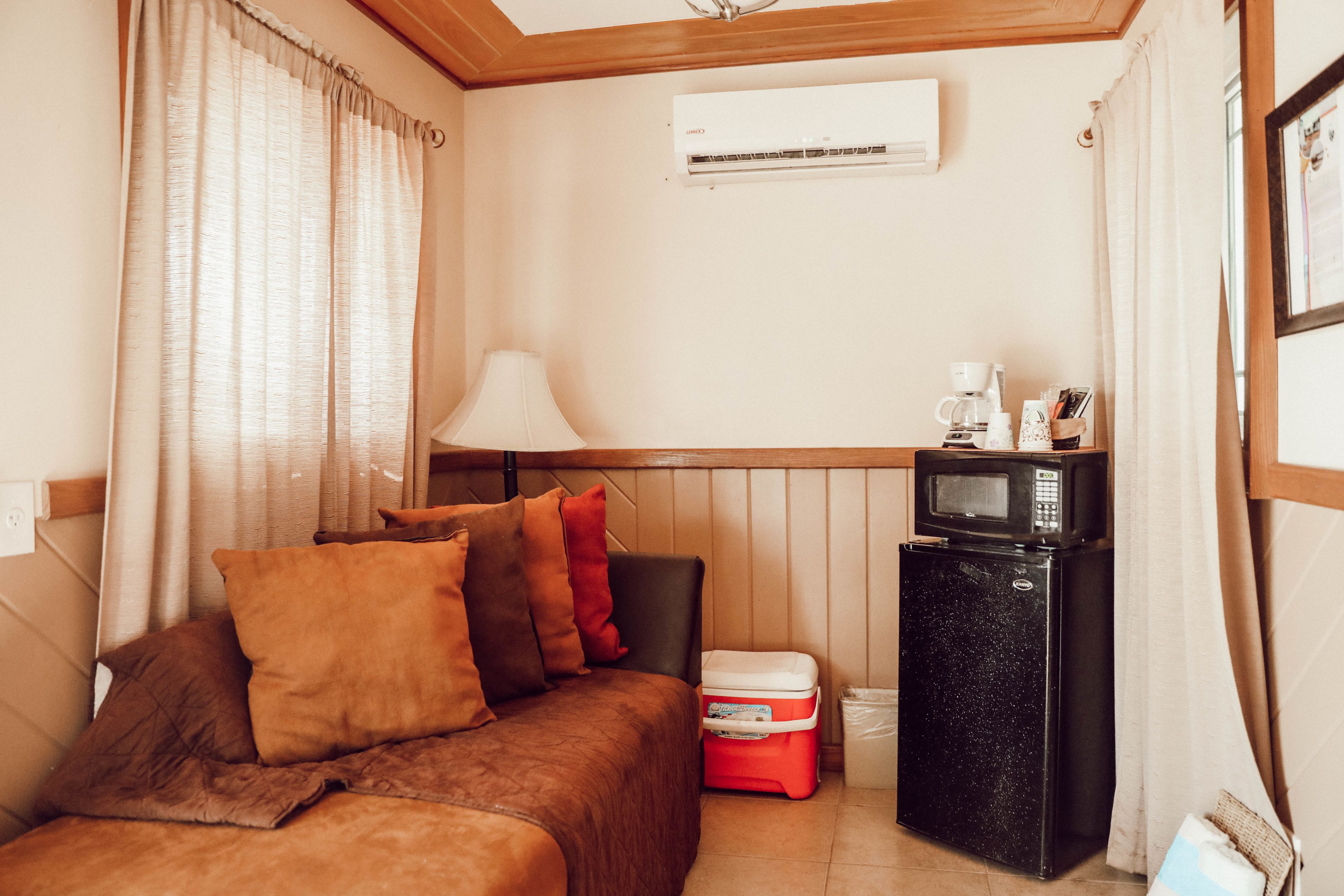 Une chambre de taille réduite comprenant un lit, une petite kitchenette, un réfrigérateur et un four à micro-ondes.