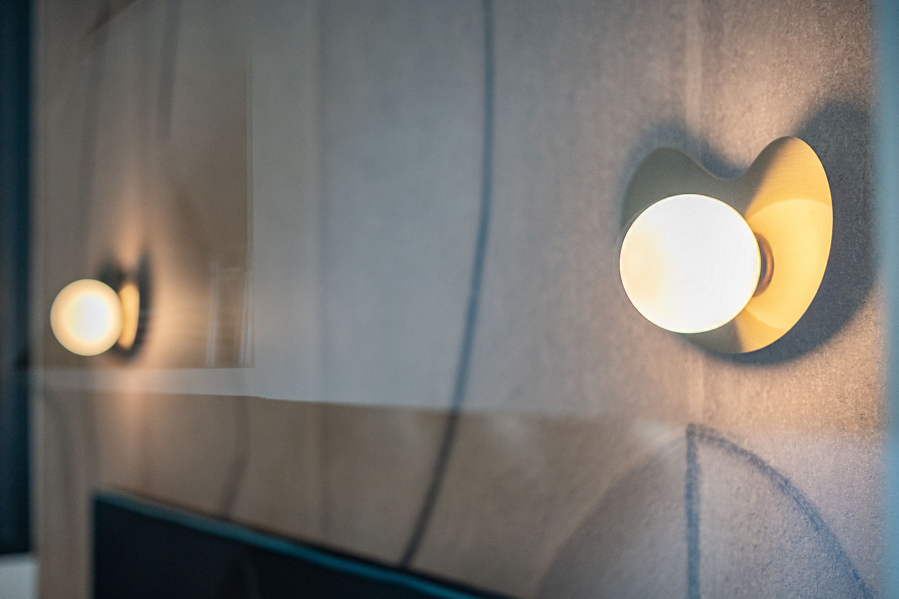 A wall with two wall-mounted light fixtures.