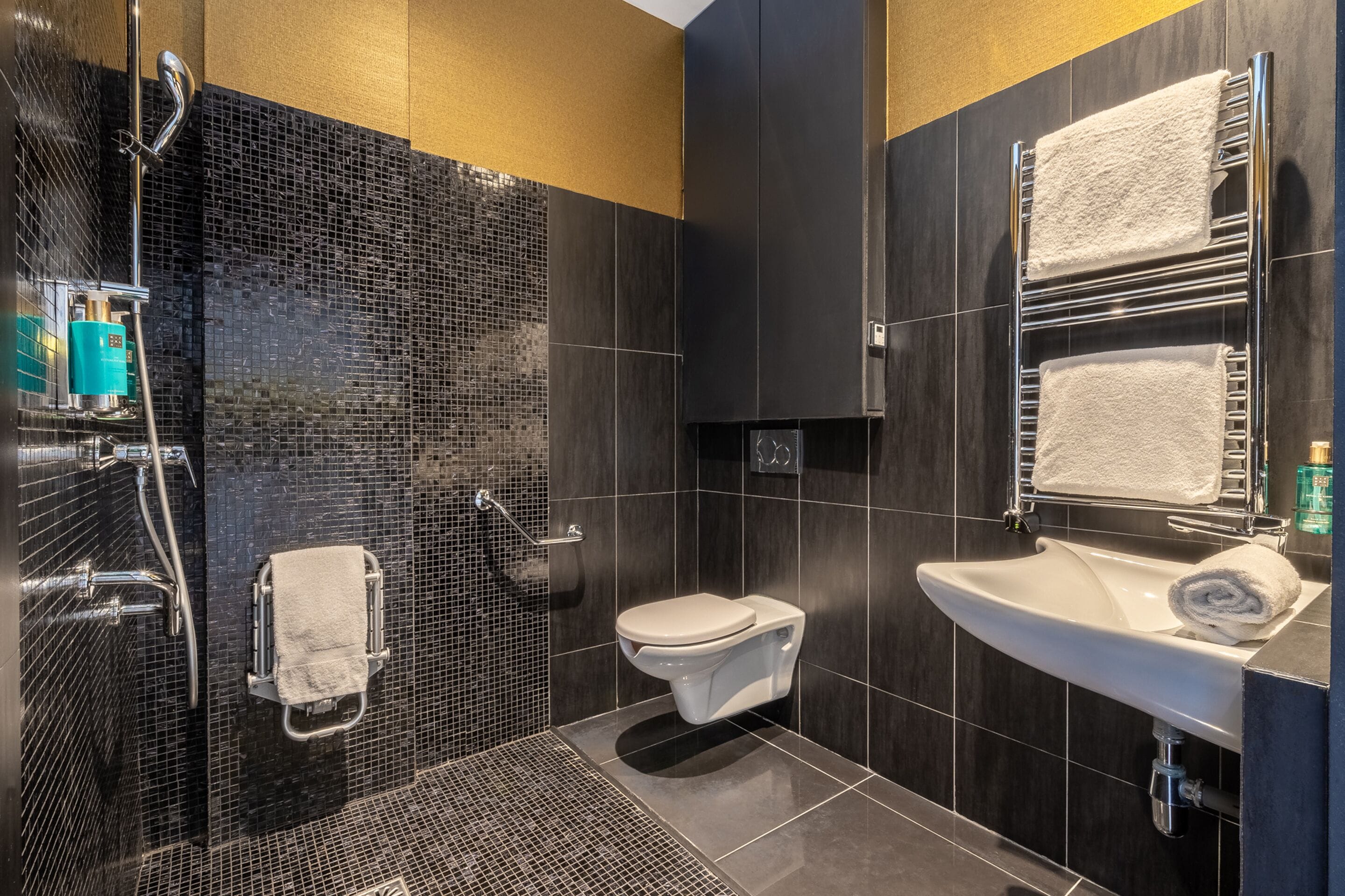 Un baño moderno con ducha, inodoro y lavamanos.