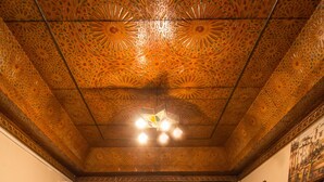 Una habitación con dos sofás, una mesa redonda con un florero y una alfombra estampada.