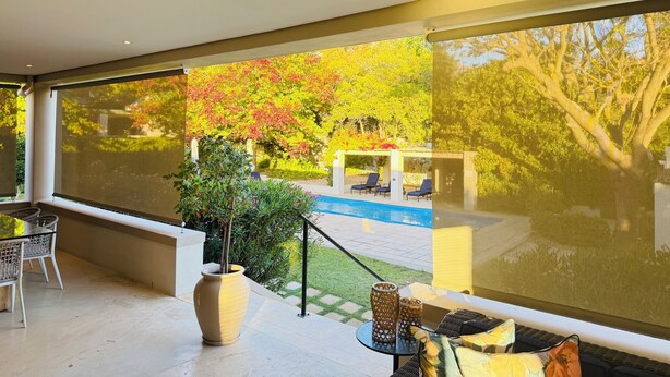 A modern outdoor seating area with a view of a pool and garden. - Residence Vive La Vie (Franschhoek)