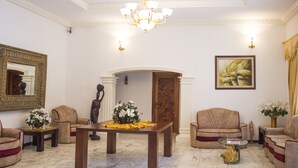 Un salón formal con piso de mármol, una mesa de centro de madera y dos sofás.