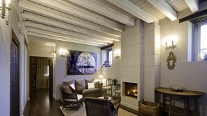 A cozy living room with a fireplace, wicker furniture, and a large wall clock. - El Morendal (Almarza)