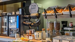 A breakfast buffet with various food items, a coffee machine, and a toaster. - B&B HOTEL Nîmes Ville Active (Nîmes)