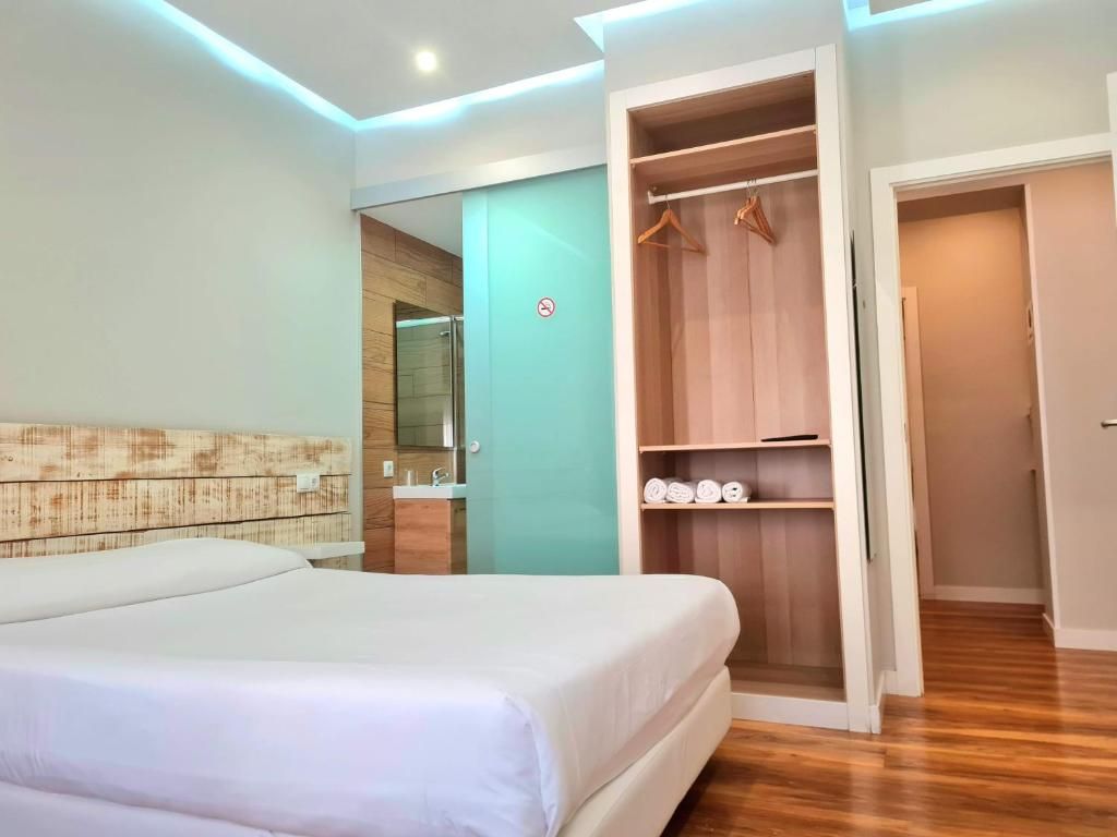 A hotel room with a bed, a walk-in closet, and a bathroom.