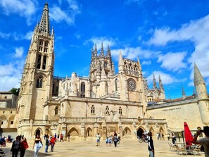 Una catedral histórica con una imponente torre de reloj y múltiples agujas.