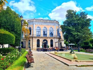 Un edificio histórico con un patio, bancos y una fuente.
