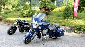 Two motorcycles parked on a gravel path with a scenic background of greenery and mountains. - Hotel Restaurant Schweizerhof (Val Muestair)