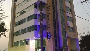 Un hotel de varios pisos con un letrero vertical destacado en la fachada.