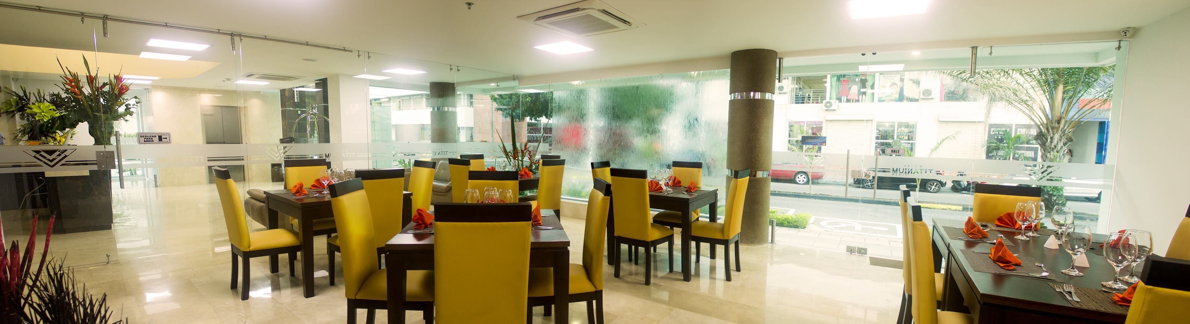 Un restaurant avec des chaises et des tables jaunes, de grandes fenêtres et une vue sur la rue.