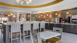 Un restaurant moderne doté d’un bar, de tables et de chaises aux motifs originaux, ainsi que d’un comptoir de cuisine avec des machines à café.