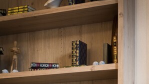 Une bibliothèque en bois, avec des livres et des objets décoratifs.