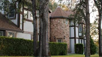 A house with a stone tower, a white facade, and a traditional design.