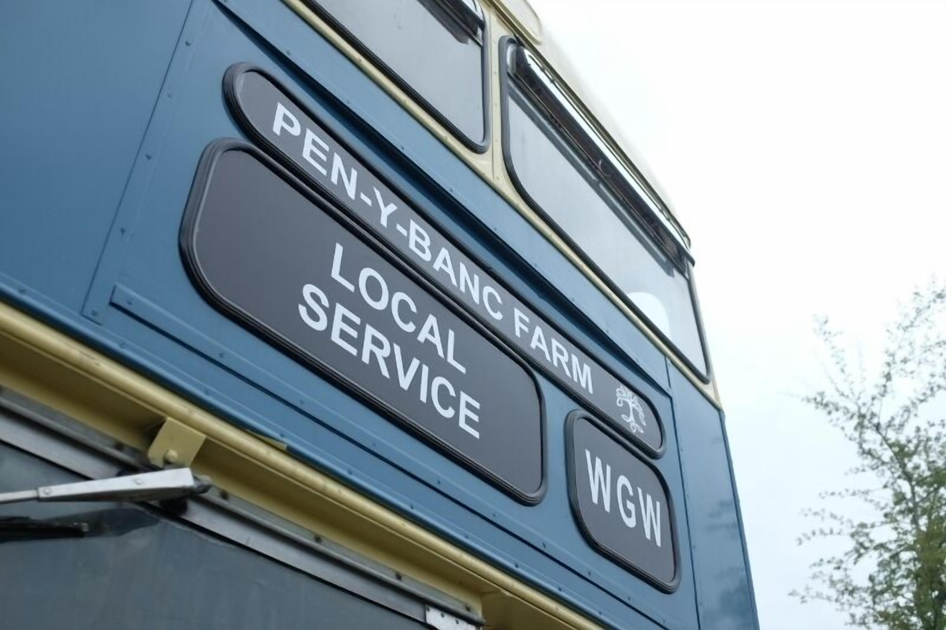 A bus with the text "PEN-Y-BANC FARM LOCAL SERVICE" and "WGW" on its side.