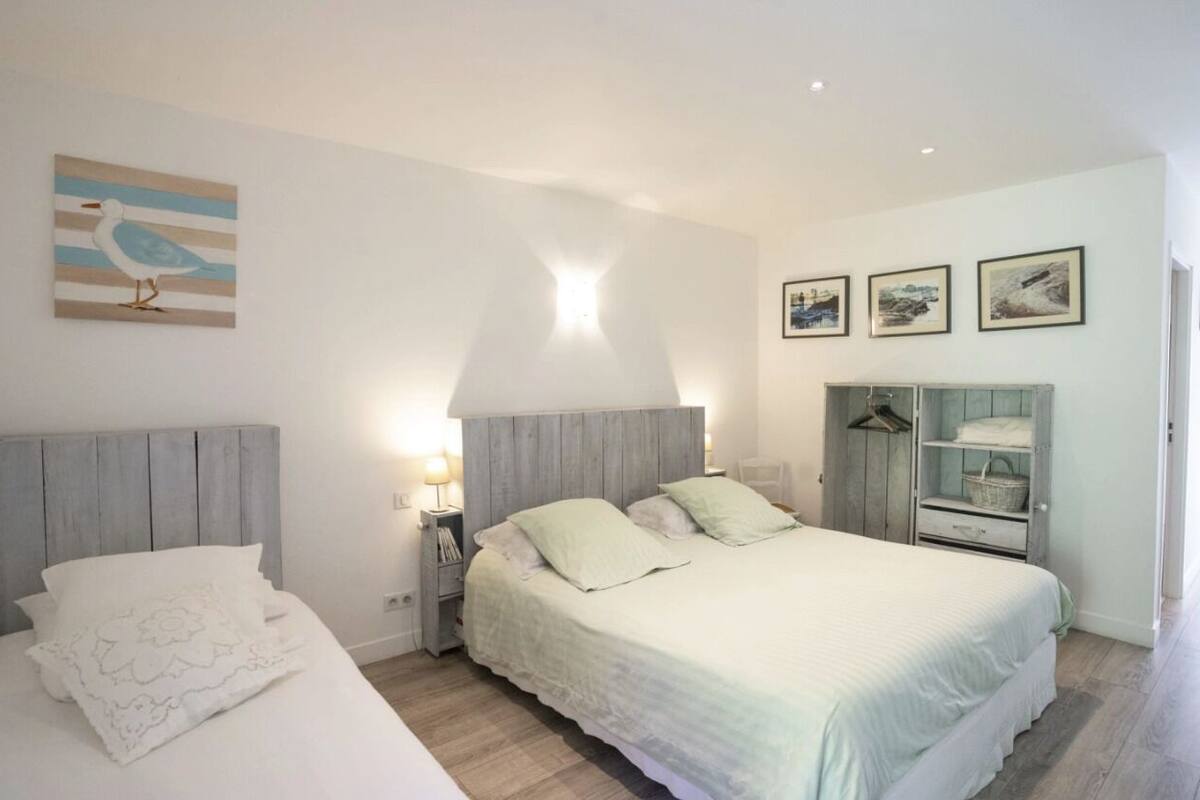 A bedroom with a bed, bedside tables, a wardrobe, and wall art.