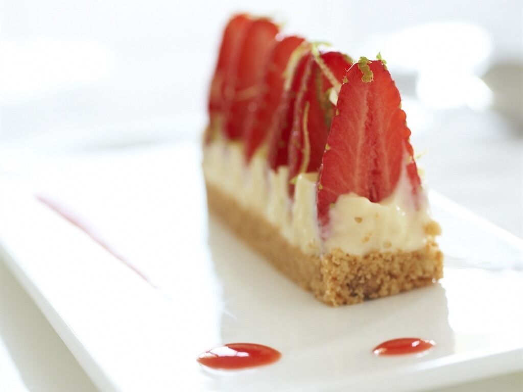 Un dessert aux fraises, présenté sur une assiette blanche.