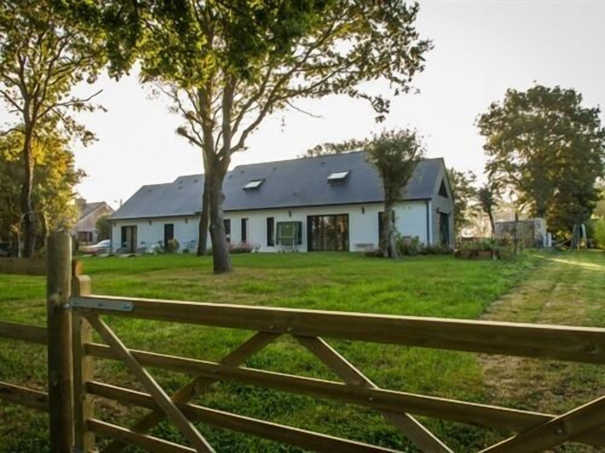 Une maison de plain-pied avec un toit en pente, un porche à l’avant et une pelouse bien entretenue.