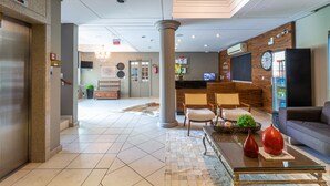 A modern lobby with a reception desk, seating area, and a chandelier. - Hotel Werlich (Sao Jose)
