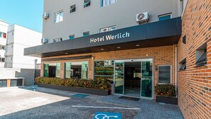 A hotel with a modern facade, a clear entrance, and a wheelchair-accessible parking space. - Hotel Werlich (Sao Jose)