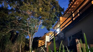 A residential building with a balcony and a tree in the foreground. - EstrelaMar Ferradura Pousada, Restaurante & Spa (Búzios)