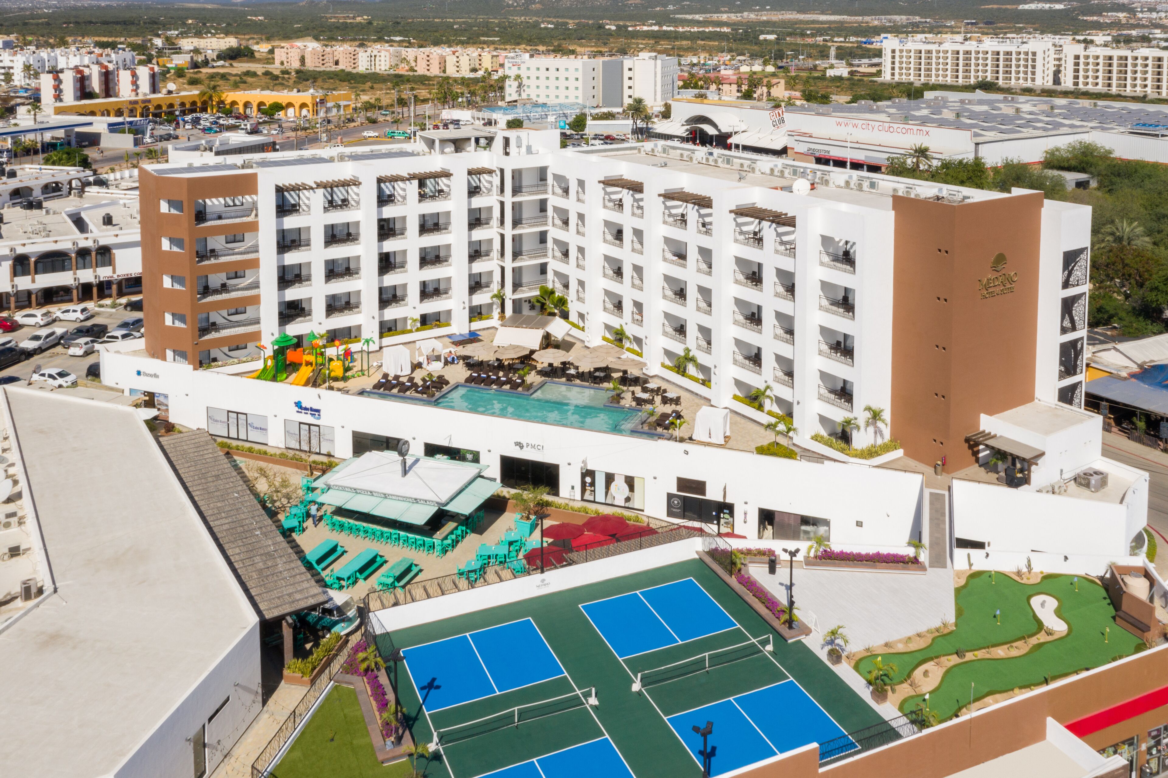 Un hôtel à plusieurs étages doté d’une piscine sur le toit, de courts de tennis et d’un espace de jeux pour enfants.