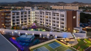 A hotel with multiple floors, outdoor swimming pool, tennis courts, and a children's play area. - Medano Hotel and Spa (Cabo San Lucas)