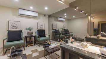 Una habitación de hotel moderna con zona de estar, tocador con espejo y kitchenette.