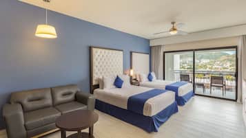 Une chambre d’hôtel avec deux lits, un canapé, une petite table et un balcon avec vue.