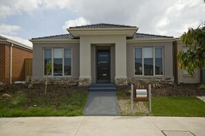 A modern two-story house with a front entrance, a mailbox, and a well-maintained lawn. - Villa Saltwater (POINT COOK)