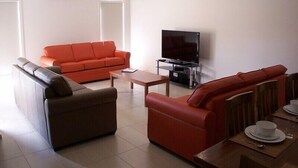 Ein Wohnzimmer mit zwei Sofas, einem Couchtisch und einem Fernseher.