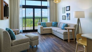 A modern living room with a sectional sofa, a small table, and a TV mounted on the wall. - Element by Marriott Huntsville (Huntsville)