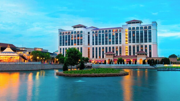 A large hotel with multiple stories, a central courtyard, and a body of water in front. - Element by Marriott Huntsville (Huntsville)