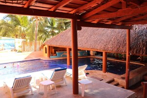 Una piscina al aire libre, sillones reclinables de piscina