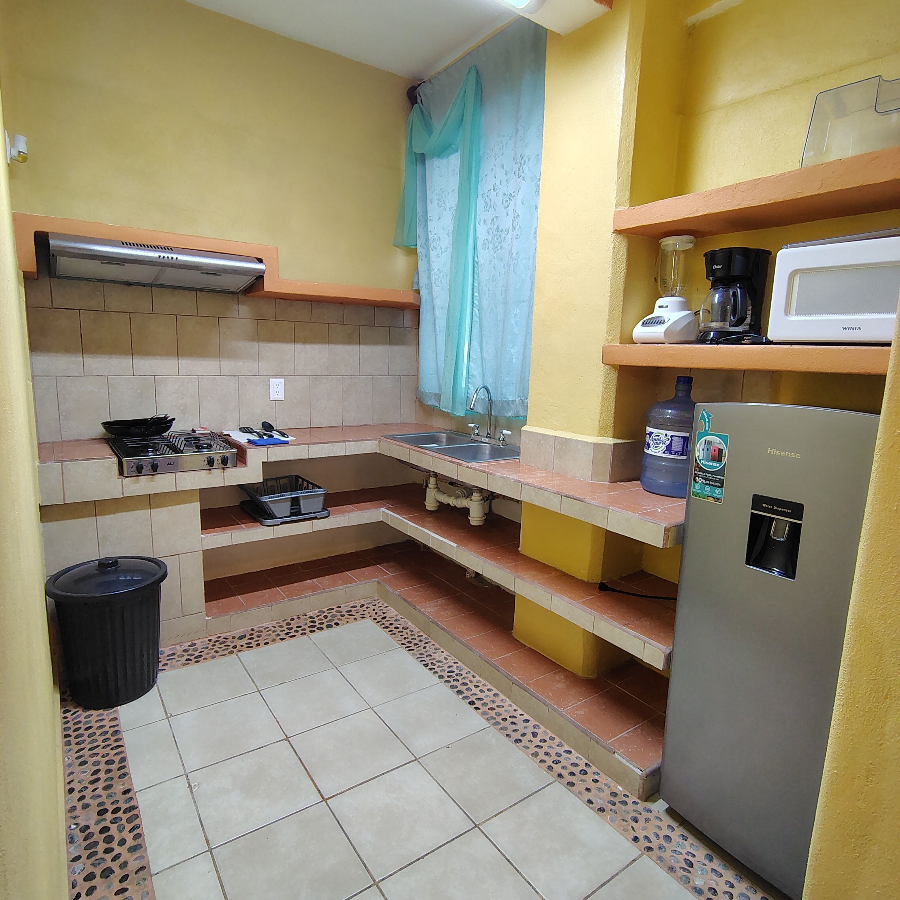 A compact kitchen with a gas stove, sink, and a refrigerator.