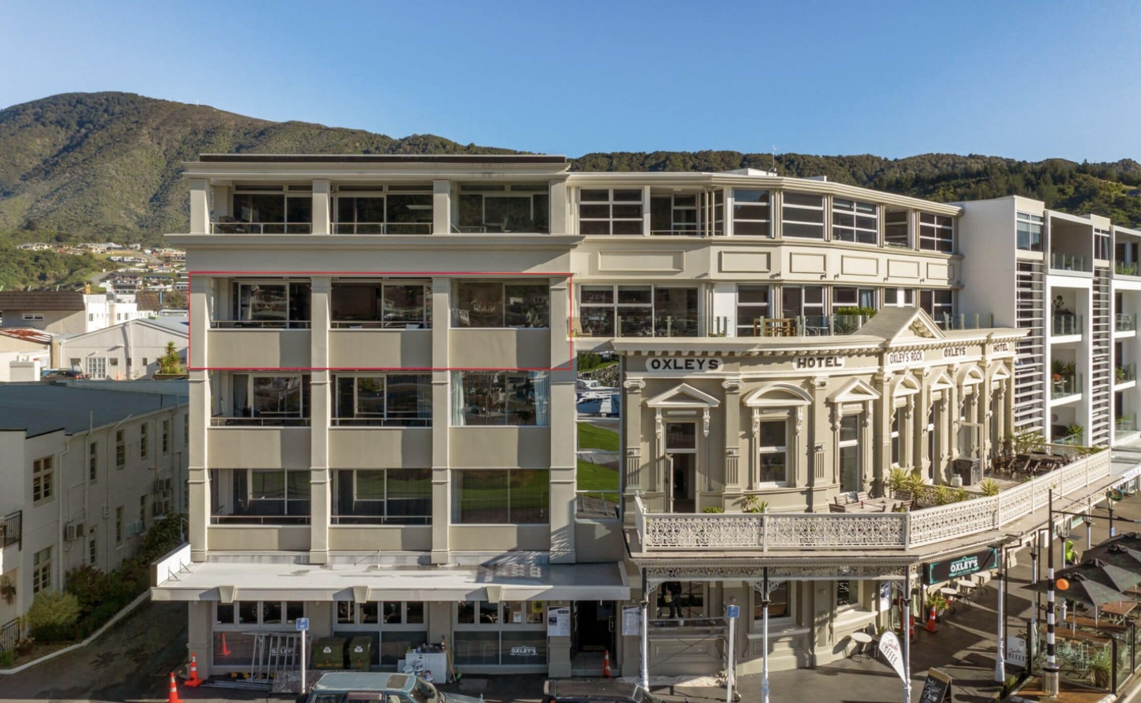 Een hotel met meerdere verdiepingen, in een klassieke architectuur, met een opvallende entree, een balkon en bewegwijzering.