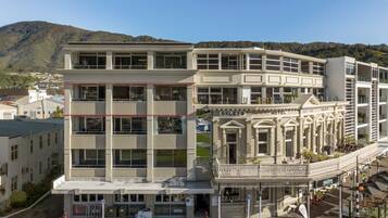 Een hotel met meerdere verdiepingen, in een klassieke architectuur, met een opvallende entree, een balkon en bewegwijzering.