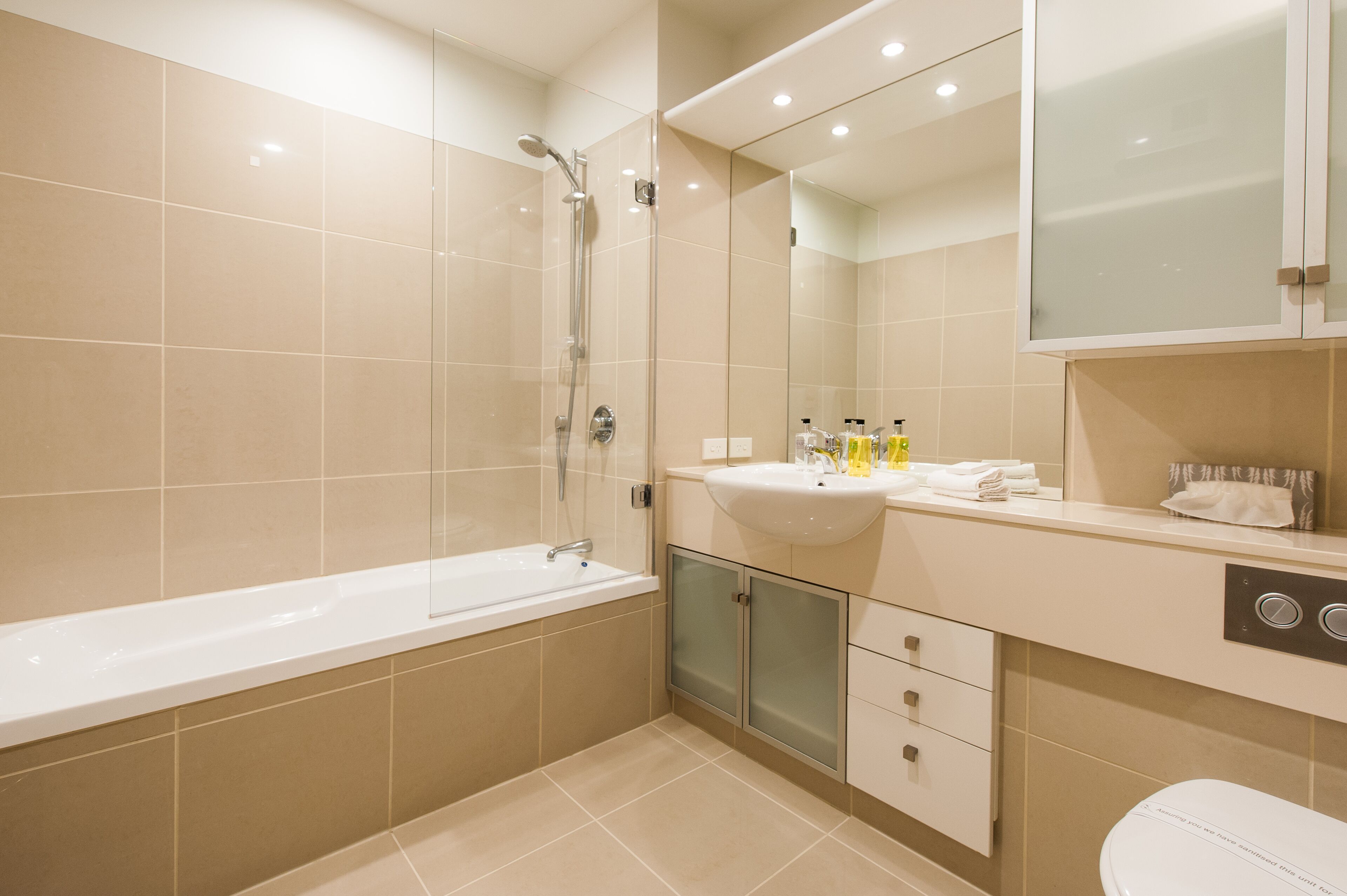 A modern bathroom with a bathtub, sink, and toilet.