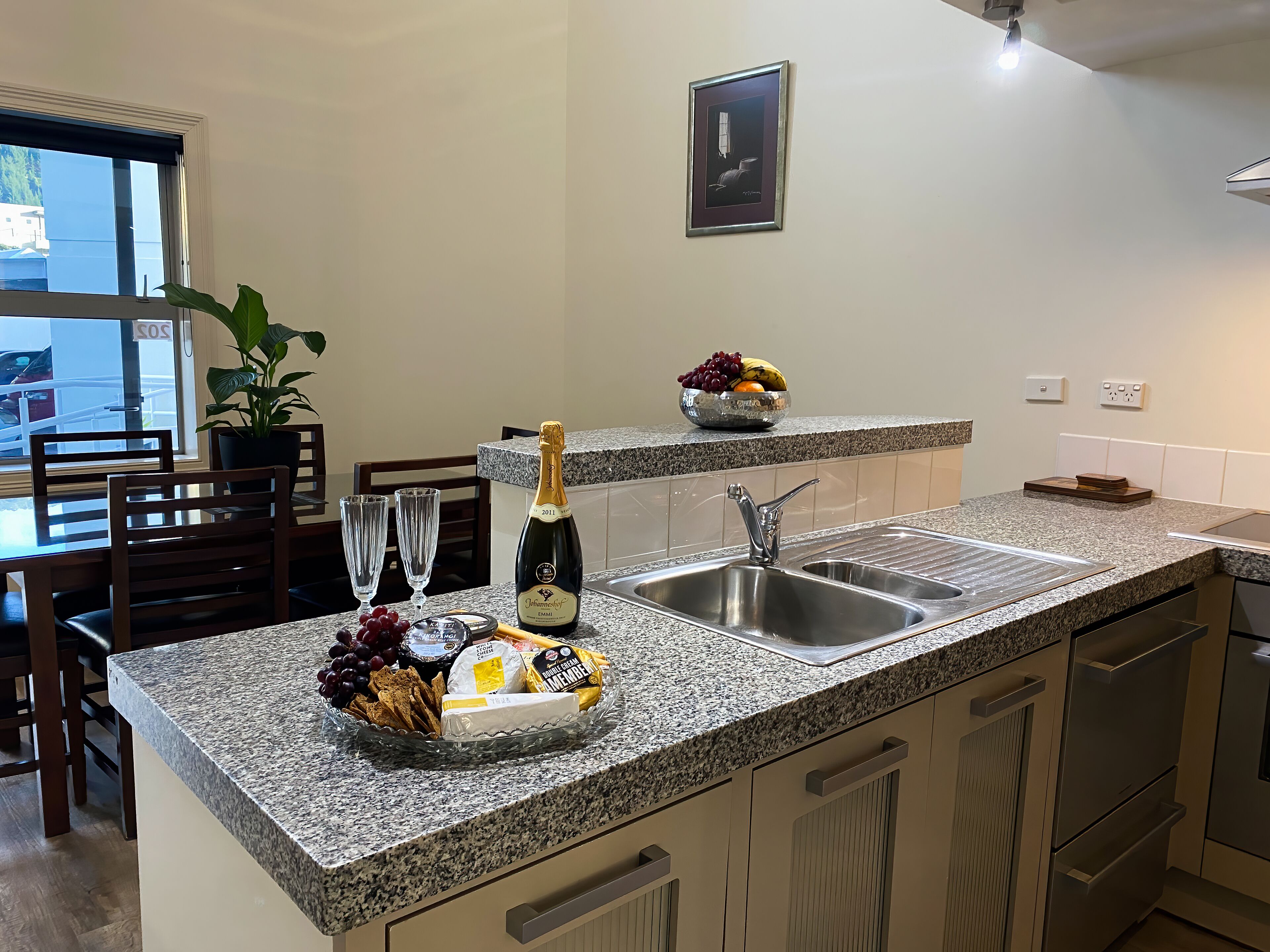 Une cuisine dotée de plans de travail en granit, d’un évier et d’un coin repas avec des chaises et une table.