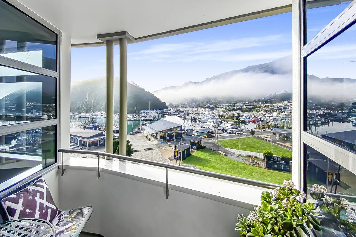 A balcony with a view of a marina and mountains.