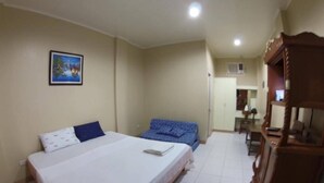 A bedroom with a large bed, a smaller bed, a desk, and a wardrobe. - Northsky Beach Resort (Sogod)