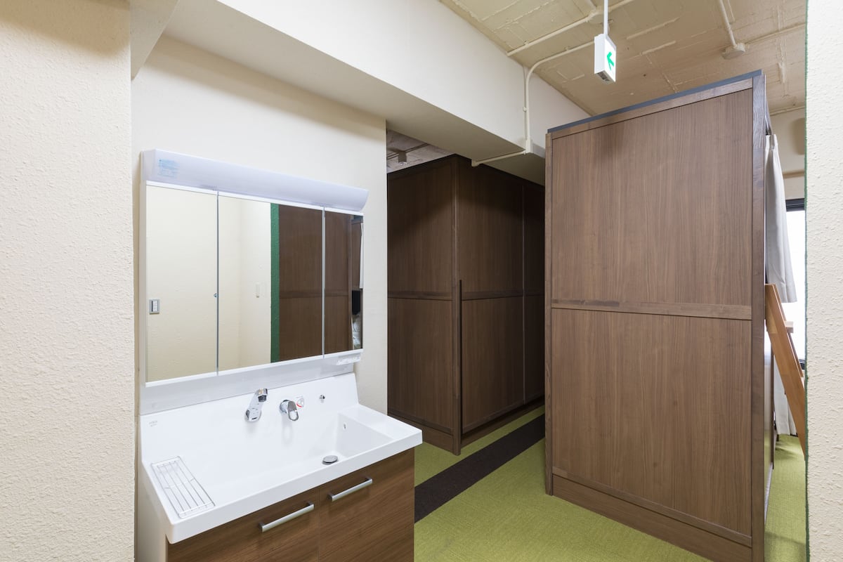 A bathroom with a white sink, mirror, and wooden cabinets.