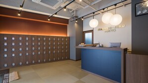 A reception area with a blue counter, wooden lockers, and a wall-mounted map. - Tokyo Guest House Itabashijuku - Hostel (Tokyo)