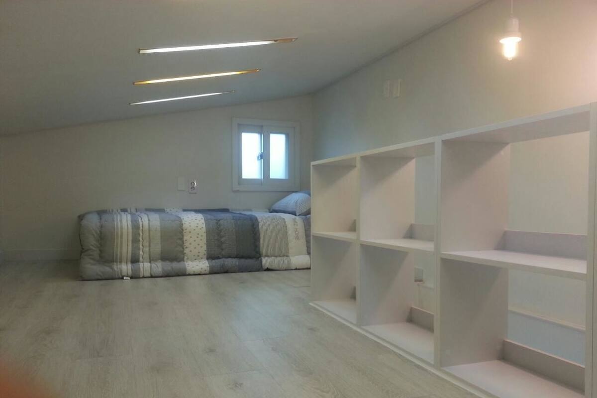A room with a sofa set, a window, and built-in shelving.