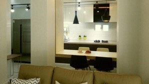Una cucina moderna con mobili bianchi, un piano di lavoro nero e luci a sospensione.